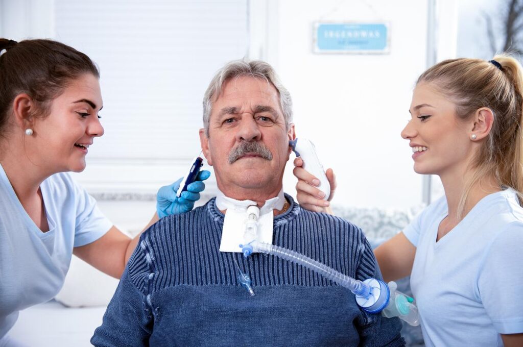 Two young pretty nurses take care of an intensely awake patient at the nursing home